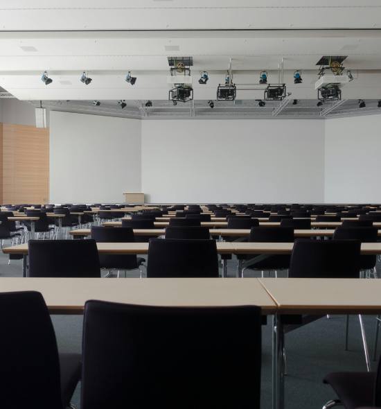 Modern conference setup with a stage, projector screen, and elegant seating arrangement